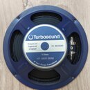 Modrý kruhový reproduktor s černou membránou. Uprostřed je bílá nálepka s modrým logem a nápisy Turbosound, Designed and Engineered in England, TS-8G…