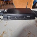 Černý obdélníkový UHF přijímač s dvěma anténami a napájecím adaptérem. Na předním panelu jsou nápisy the litbone, UHF RECEIVER, POWER, CH, RF LEVEL a…
