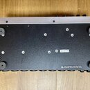 Fotografie zachycuje spodní stranu černého elektronického zařízení s hliníkovým horním profilem. Na spodní části je vidět bílá nálepka s označením Z7…