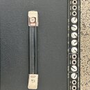 Detailní pohled na ovládací panel a úchyt černého kytarového komba s texturovaným povrchem. Na panelu jsou nápisy INPUTS (TWEED, BLONDE, BLACK), CHAN…