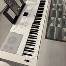 Bílá digitální pianola s klávesnicí a integrovaným stojanem. Na horním panelu je nápis YAMAHA a modelové označení Clavinova CLP-645. V držáku na noty…