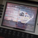 Detailní záběr na displej digitálního klavíru nebo syntezátoru. Na obrazovce je vidět rozhraní s nápisy MAIN, NewSong, Lyrics, Score, Cool8Beat a Gra…