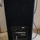 Zadní strana černého reproduktoru potaženého hrubým textilem. Na spodním ovládacím panelu je nápis LEMi a model H 350A, dále popisky INPUT XLR a VOLU…
