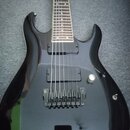 Černá elektrická kytara s lesklým povrchem a hnědým hmatníkem. Nástroj je vybaven dvěma černými humbuckery, stříbrným Tremolo mostem a jedním bílým o…