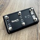 Černý nožní spínač s pětiknoflíkovým rozložením a texturovaným okrajem. Na čelní straně je bílý nápis Spark CONTROL X a kontrolky s popisky POWER, CO…