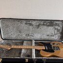 Elektrická kytara s gold metallic povrchem těla a javorovým hnedým hmatníkem v černém tvrdém kufru s šedou výstuhou. Na hlavě je nápis Fender a model…