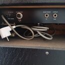 Fotografie zachycuje zadní panel černého elektronického zařízení s několika konektory a popisky. Jsou zde nápisy AC OUTLET, MAX. 200W, POWER FUSE, FU…