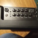 Detailní pohled na ovládací panel černého komba s nápisem SUPER FLY. Panel obsahuje deset otočných ovladačů s popisky REVERB, TREBLE, BASS, VOLUME a…
