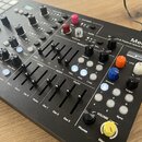 Černý hybridní syntetizátor s nápisem Medusa a textem Dr. Alex & Polyend Hybrid Synthesizer. Zařízení obsahuje klaviaturu, množství posuvníků, otočný…