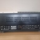 Zadní strana černého kytarového komba v texturovaném krytu. Na zadním panelu jsou nápisy „VHT AMPLIFICATION“, „MODEL G-100-EX“ a „SERIAL 14“. Jsou zd…