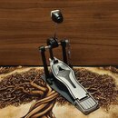 Černý bicí pedál s kovovou stoupací deskou v bílo-stříbrném provedení. Na desce je vyrytý stylizovaný tvar připomínající kapičku nebo plamen. Pedál j…