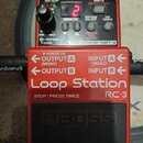 Červený efekt pedál Loop Station RC-3 značky BOSS. Horní panel obsahuje digitální displej s červenou číslicí 2, ovládací knoflík a tlačítka s nápisy…