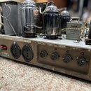 Fotografie zachycuje vnitřek elektronického zařízení s několika skleněnými elektrónkami. Na jedné z komponent je viditelný nápis TESLA TC427 1M5A NF…
