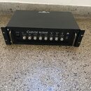 Černý basový zesilovač v rackovém provedení s nápisem CARVIN B1500 BASS AMPLIFIER. Přední panel obsahuje několik ovládacích knoflíků, přepínačů a vst…