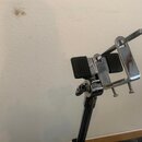 Chromovaná kovová držák na noty s dvěma černými gumovými plochami. Na utahovacím šroubu je viditelný nápis LOCK. Povrch je lesklý, s mírnými odlesky…