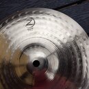 Kovový činel typu splash s povrchem z jemných hloubkových důlků. Na povrchu je černý nápis PLANET, logo Zildjian a text SPLASH 10"/25 cm. Povrch vyka…