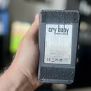 Zadní strana kytarového efekt pedálu v černém textilním krytí. Na stříbrném štítku je uveden název cry baby MINI 535Q a nápisy VOLUME, RANGE, INSTRUM…