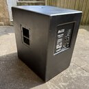 Černý subwoofer v hranatém korpusu s texturovaným povrchem. Na zadním panelu je bílý štítek s nápisy ALTO PROFESSIONAL, TS218S a Powered Subwoofer. J…
