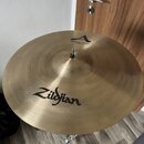 Zlatý kovový činel umístěný na stojanu. Na povrchu je černý nápis Zildjian a v horní části logo A s textem MEDIUM CRASH 18" / 45 cm. Povrch vykazuje…
