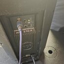 Záběr na zadní panel černého aktivního reproduktoru. Na ovládacím panelu jsou nápisy LIMITER, SIGNAL, POWER, FLAT, VOCAL, BASS a LINE, dále regulační…