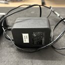 Černý síťový adaptér s plastovým povrchem a připojeným kabelem. Na štítku je uveden text TERRATIC PRODUCER, AC/AC ADAPTOR, MODEL NO: HYV1215, INPUT:…
