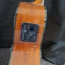 Zadní strana akustické kytary z hnědého dřeva s lakovaným povrchem. V horní části je osazený černý ovládací panel s nápisy Tuner, Phase, Volume, Bass…