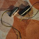 Na fotografii jsou dva elektrické snímače s připojenými vodiči v žluté a černé barvě. Jeden snímač je v kovovém krytu, druhý je otevřený s viditelným…