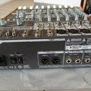 Zadovací panel šedého míchacího pultu s oranžovým rámem. Na horní části jsou vidět nápisy TAPCO a MIX 220FX, v dolní části je štítek s sériovým čísle…