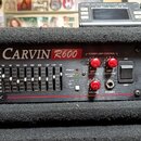 Černý kytarový zesilovač v rackovém provedení s nápisem CARVIN R600. Přední panel obsahuje několik červených otočných ovladačů, řadu posuvníků ekvali…