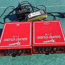 Dvě červené efektové pedály s bílým nápisem „SOUND STUDIO X-L“ a logem „ProCo“. Na horní straně pravého pedálu je malý bílý štítek s nápisem „HAMBURG…
