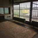 Na fotografii není žádný hudební nástroj ani příslušenství. Je zde zobrazen prázdný interiér místnosti s betonovou podlahou, radiátory a velkým oknem…