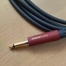Černý kabel s červeným konektorem typu jack. Na červené části konektoru je bílý nápis silentPLUG. Povrch kabelu i konektoru vypadá čistě a bez vidite…