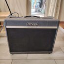 Kytarový kombo zesilovač s šedým textilním potahem a černou přední mřížkou. Na horní části je bílo-černý nápis FENDER a pod ním na stříbrné liště tex…