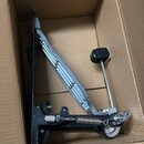 V kartonové krabici se nachází černý bicí pedál s kovovými prvky. Na zařízení není vidět žádný značka, logo ani modelové označení. Povrch černého rám…