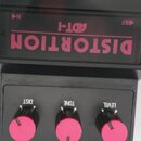 Černý kytarový efekt s nápisy v růžové barvě. Na horní části je uveden model ADT-1 a velký nápis DISTORTION, v rozích jsou označení IN a OUT. Spodní…