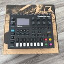 Digitální polyfonní syntetizátor značky Elektron, model Digitone. Zařízení je v černém provedení s displejem a řadou ovládacích knofíků, tlačítek a v…