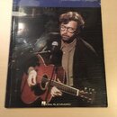 Fotografie znázorňuje notovou knihu nebo songbook s nápisy eric clapton a from the album eric clapton unplugged. Na obálce je vyobrazen hudebník s br…