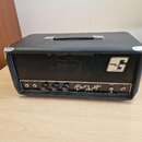Černý basový kombozesilovač s texturovaným povrchem a kovovými rohy. Na předním panelu je nápis Bass Amplifier, logo G s textem GENA TONE a označení…