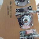 Detail zadní strany hlavy kytary z přírodního dřeva se třemi chromovanými ladicími mechanismy. Na dřevě je černý nápis SERIAL NUMBER MX20151601 a MAD…