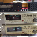 Tři stohované rackové jednotky značky Fostex. Horní zařízení je černý DVD MULTITRACK RECORDER s označením DV824, který má v displeji nápis No files!-…