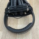 Černá velká sluchátka s černé kabeláží omotanou kolem mušlí. Na vnitřní straně náušníku je vyražen nápis SENNHEISER. Povrch plastů a polstrování vyka…