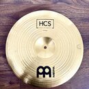 Zlatý kovový činel s výrazným rýhováním povrchu. Na horní části je nápis HCS, pod ním MADE IN GERMANY a 14" China. Ve spodní části je umístěno černé…