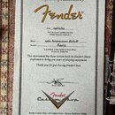Fotografie zobrazuje papírový certifikát pravosti s nápisem Certificate of Authenticity a logem Fender. Dokument obsahuje ručně vyplněné údaje: Date…