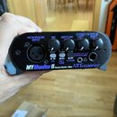Černý osobní monitor a mixér s nápisem MYMonitor II Personal Monitor / Mixer ARTcessories™. Zařízení má mikrofonní vstup XLR, čtyři otočné ovladače a…