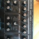 Detailní pohled na ovládací panel efektového procesoru Boss ME-80 Guitar Multiple Effects. Zařízení má černý povrch s bílými nápisy a stříbrnými otoč…