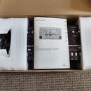 V kartonové krabici s polystyrenovými výplněmi je umístěn fialový syntetizátor. Na přístroji jsou vidět nápisy Analog Bass Line, DISTORTION, TIME MOD…