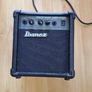 Černý basový kombozesilovač s texturovaným povrchem a plastovými rohy. Na horním panelu je nápis IBZ1B BASS AMPLIFIER a ovládací prvky s popisky INPU…