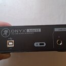 Zadní strana černého USB audio rozhraní s nápisy ONYXX Artist 1-2 a 2x2 USB AUDIO INTERFACE. Zařízení obsahuje jeden USB port s označením 2.0, symbol…
