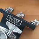 Detailní pohled na černý kovový držák s chromovanými šrouby a klíčem. Na bílém štítku je uveden nápis Pearl I.S.S. INTEGRATED SUSPENSION SYSTEM PAT.…