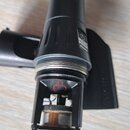 Detailní pohled na černý mikrofon s viditelnou membránou v dolní části. Na těle je nápis SMULE a pod ním MODEL RFA. Na horní části kapsle se nachází…